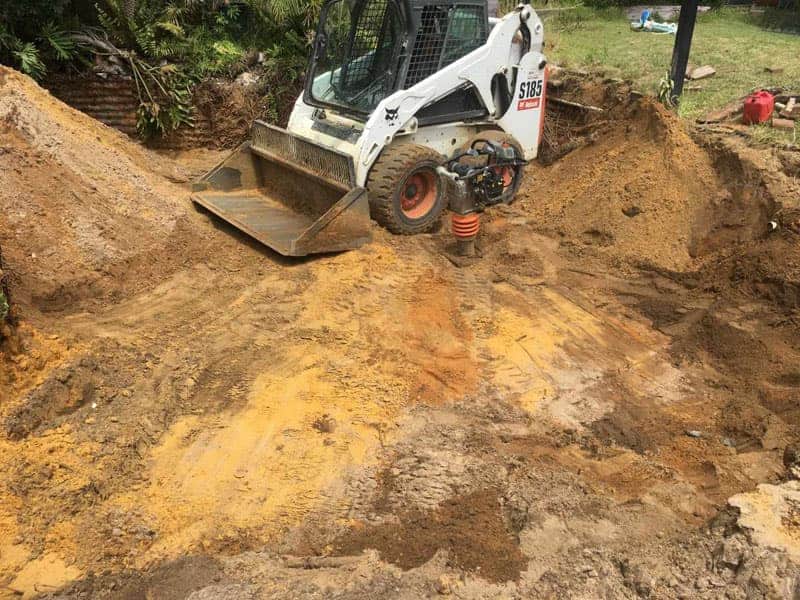 Bobcat removing a swimming pool and moving soil